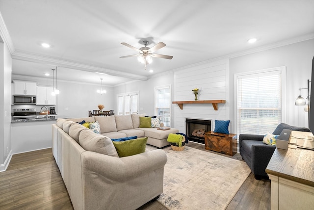 living room featuring ceiling fan, a fireplace, dark hardwood / wood-style floors, and ornamental molding