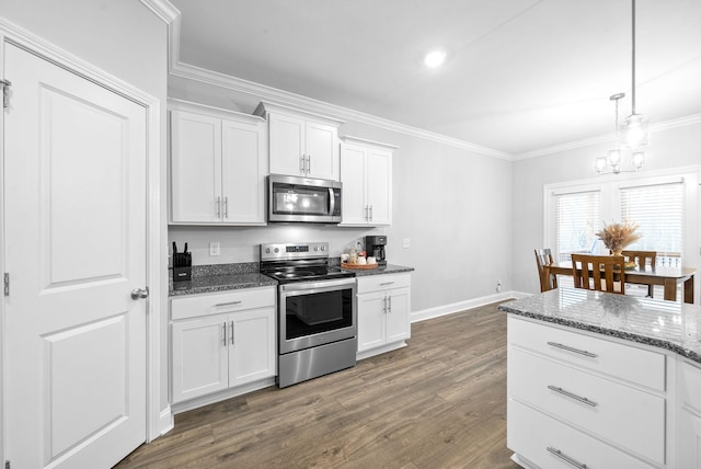 kitchen with dark stone counters, white cabinets, dark hardwood / wood-style floors, appliances with stainless steel finishes, and decorative light fixtures