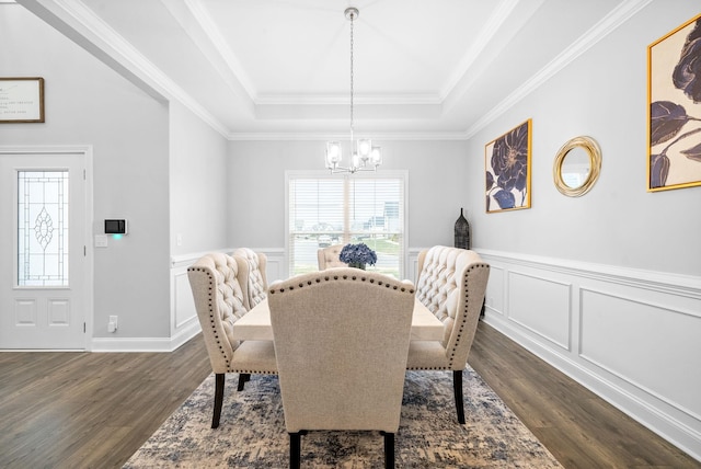 dining area featuring a tray ceiling, ornamental molding, dark hardwood / wood-style floors, and a notable chandelier