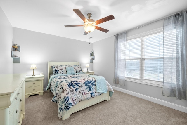 carpeted bedroom with multiple windows and ceiling fan