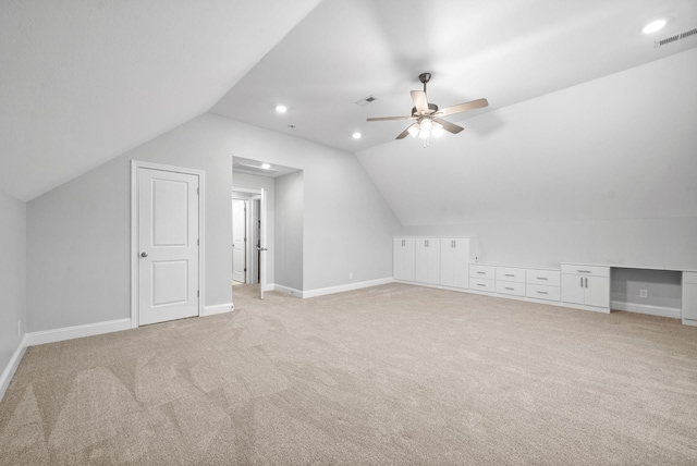 additional living space featuring ceiling fan, light colored carpet, and vaulted ceiling