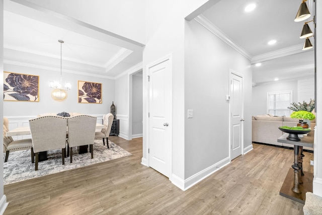 dining room with wood-type flooring, crown molding, and a notable chandelier