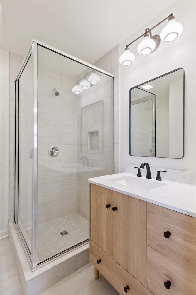 bathroom featuring vanity and an enclosed shower