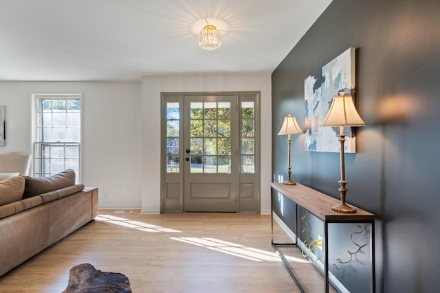 entryway featuring a chandelier and light hardwood / wood-style floors