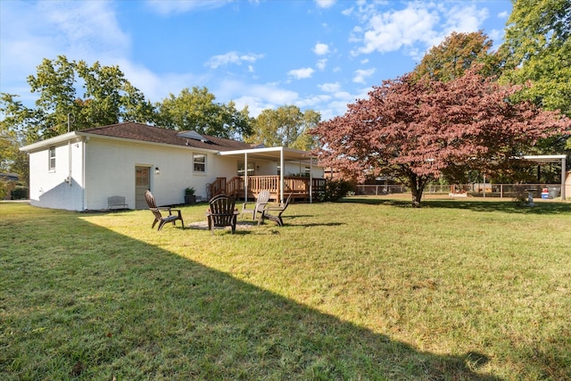 view of yard with a deck and an outdoor fire pit