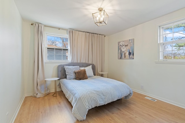 bedroom featuring a chandelier and wood-type flooring