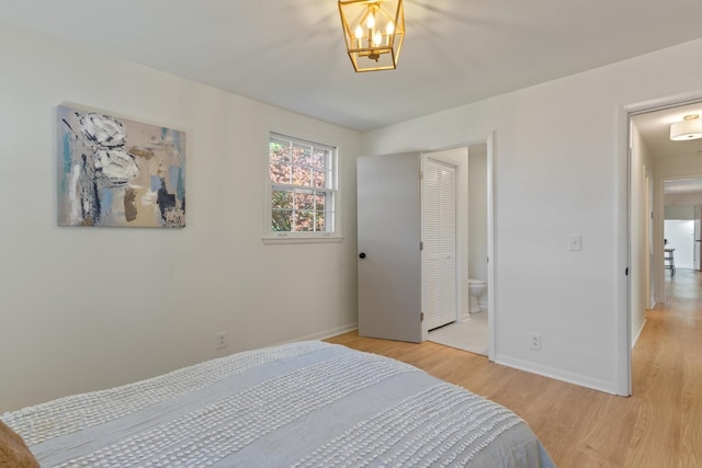 bedroom featuring ensuite bathroom and light hardwood / wood-style flooring