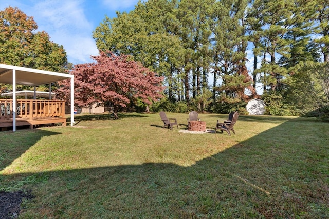 view of yard featuring a fire pit and a wooden deck