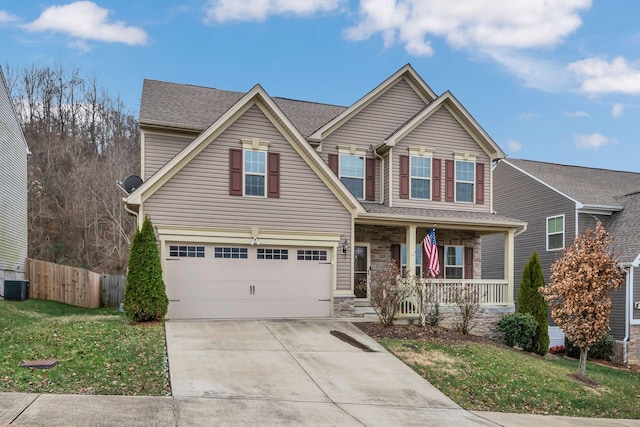 craftsman inspired home with covered porch, cooling unit, a garage, and a front yard