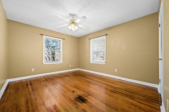 spare room with a textured ceiling, hardwood / wood-style flooring, and ceiling fan