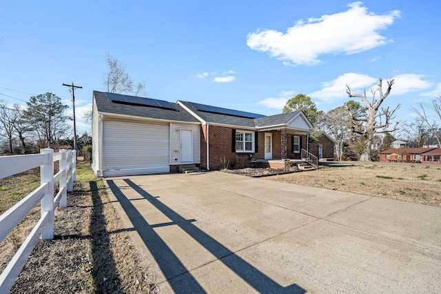 ranch-style home with solar panels and covered porch