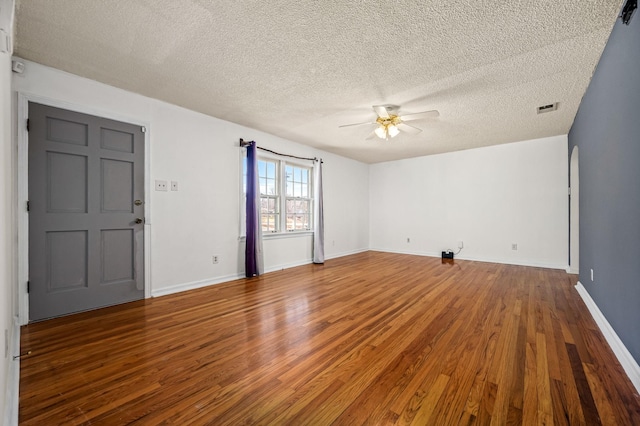 empty room featuring hardwood / wood-style flooring, ceiling fan, and a textured ceiling