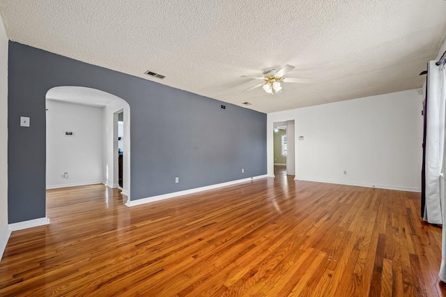 spare room with hardwood / wood-style flooring, ceiling fan, and a textured ceiling