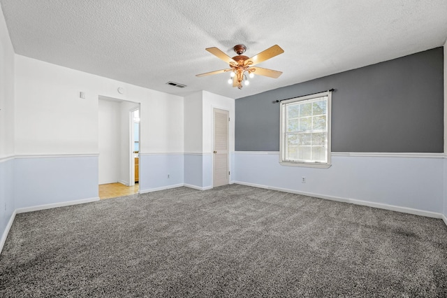 carpeted empty room with ceiling fan and a textured ceiling