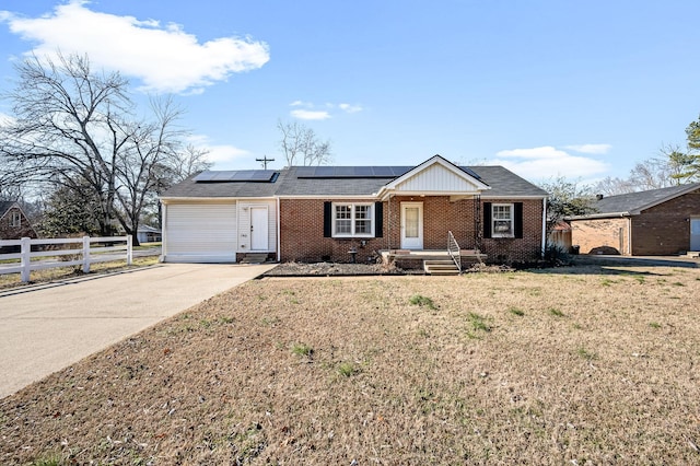 ranch-style house with a front yard and solar panels