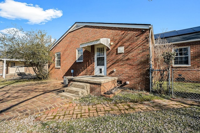 rear view of property with cooling unit and solar panels