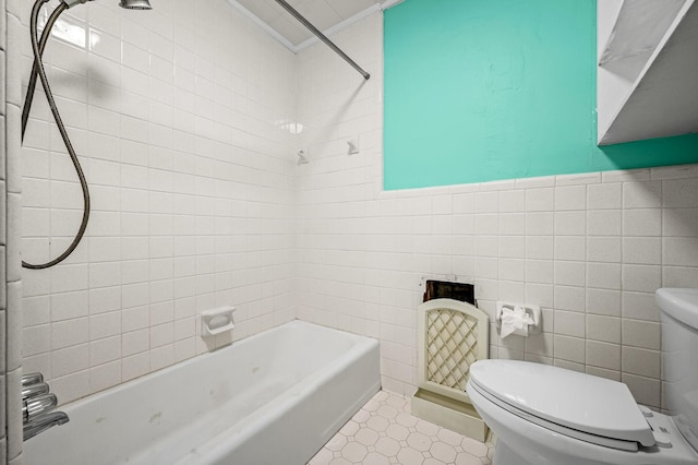 bathroom featuring crown molding, tiled shower / bath, tile patterned flooring, toilet, and tile walls