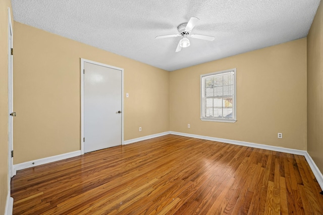 empty room featuring ceiling fan, a textured ceiling, and hardwood / wood-style flooring