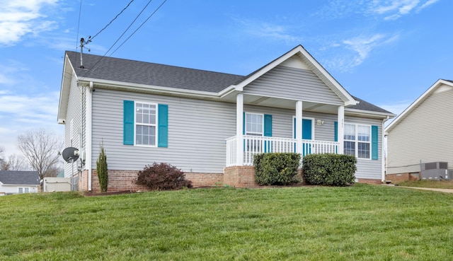 view of front of property featuring central AC unit, covered porch, and a front yard