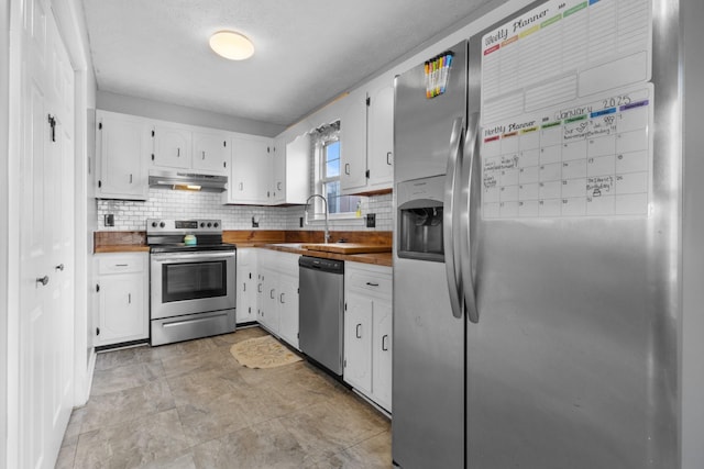 kitchen featuring backsplash, white cabinetry, sink, and appliances with stainless steel finishes