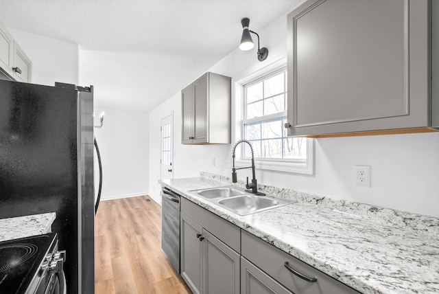 kitchen featuring sink, appliances with stainless steel finishes, gray cabinetry, and light hardwood / wood-style flooring