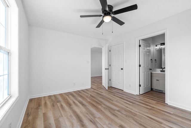 unfurnished bedroom with ensuite bathroom, ceiling fan, a closet, and light hardwood / wood-style flooring