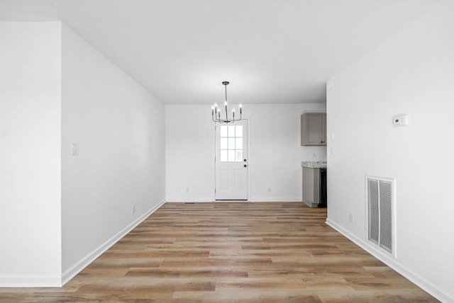 interior space with a chandelier and light hardwood / wood-style flooring