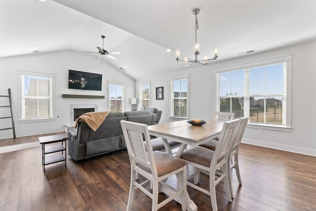 dining room with dark hardwood / wood-style flooring, ceiling fan with notable chandelier, and lofted ceiling