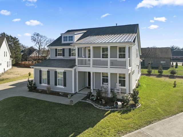 view of front of house featuring a balcony, a front lawn, and covered porch