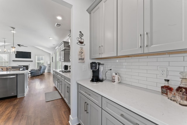 kitchen featuring light stone countertops, ceiling fan, stainless steel dishwasher, dark hardwood / wood-style floors, and lofted ceiling