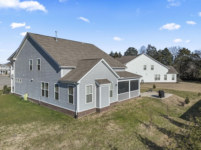 back of house with a patio area, a sunroom, and a yard