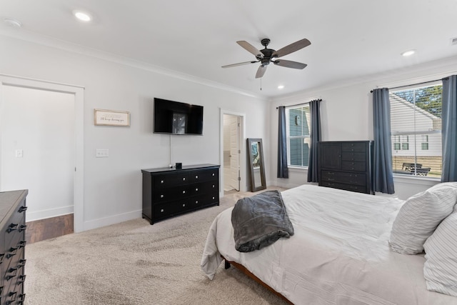 carpeted bedroom featuring ceiling fan and crown molding