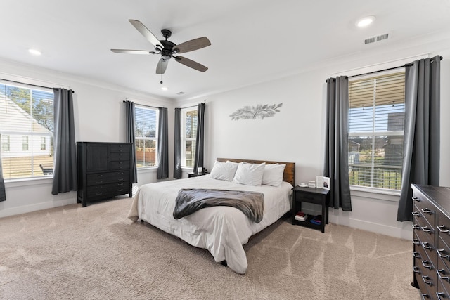 carpeted bedroom with multiple windows and ceiling fan