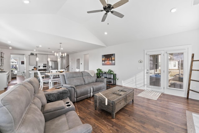 living room featuring ceiling fan with notable chandelier, vaulted ceiling, and dark wood-type flooring