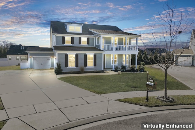 view of front facade with a lawn, a balcony, and a garage