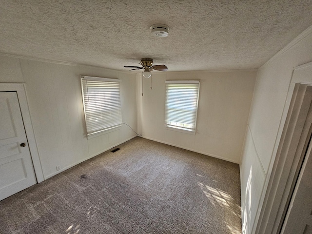 empty room with ceiling fan, carpet, and a textured ceiling