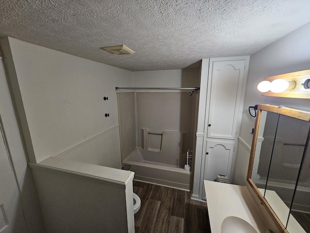 full bathroom featuring bathtub / shower combination, wood-type flooring, vanity, and a textured ceiling