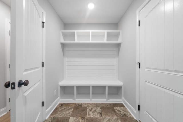 mudroom with stone finish flooring and baseboards