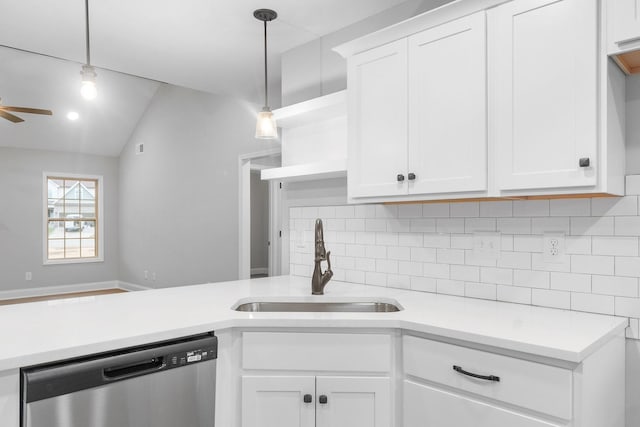 kitchen with backsplash, light countertops, stainless steel dishwasher, white cabinetry, and a sink