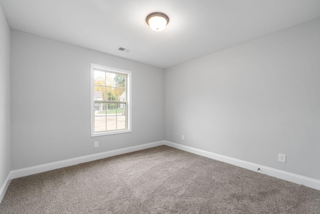 spare room with baseboards, visible vents, and carpet flooring