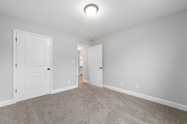 unfurnished bedroom with carpet floors and baseboards