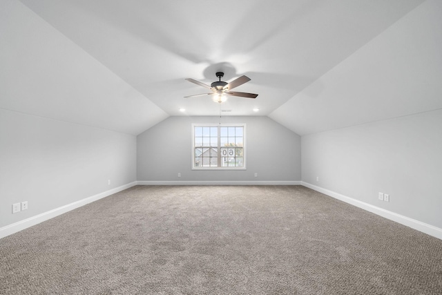 additional living space featuring vaulted ceiling, carpet, a ceiling fan, and baseboards