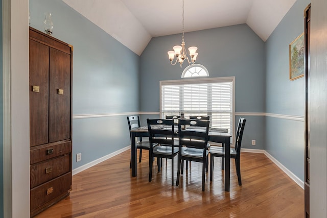 dining space featuring a chandelier, light hardwood / wood-style flooring, and lofted ceiling