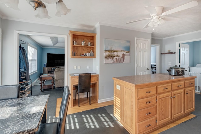 kitchen featuring dark hardwood / wood-style floors, a kitchen island, ceiling fan, and ornamental molding