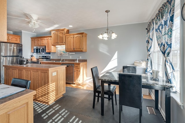 kitchen with ceiling fan with notable chandelier, sink, crown molding, appliances with stainless steel finishes, and decorative light fixtures