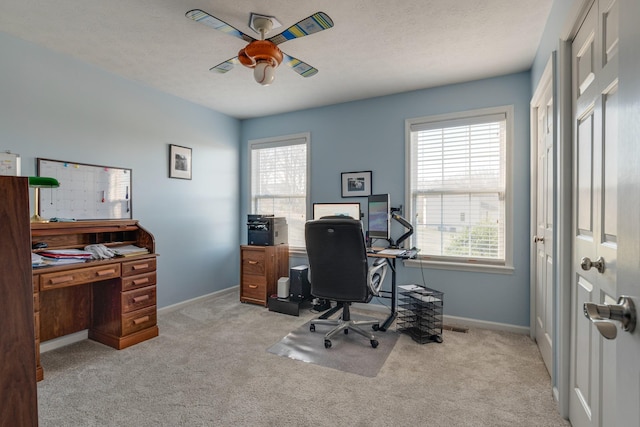 home office featuring light colored carpet, plenty of natural light, and ceiling fan