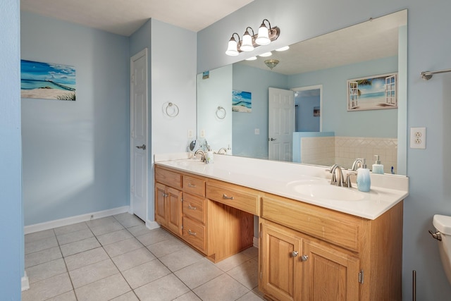 bathroom featuring tile patterned floors, a tub, vanity, and toilet