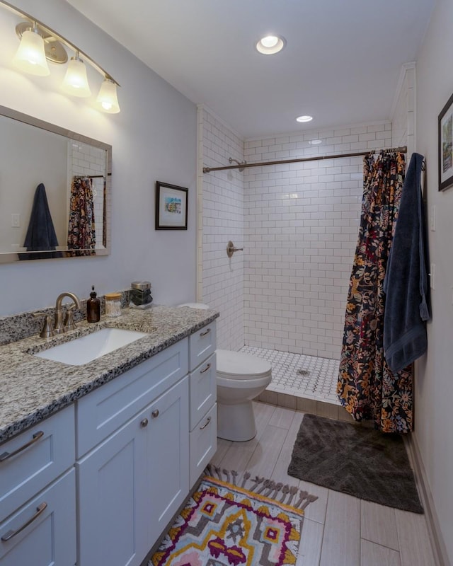 bathroom featuring a shower with shower curtain, vanity, and toilet