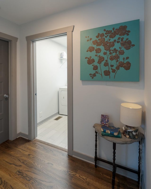 hall with washer / dryer and dark hardwood / wood-style floors