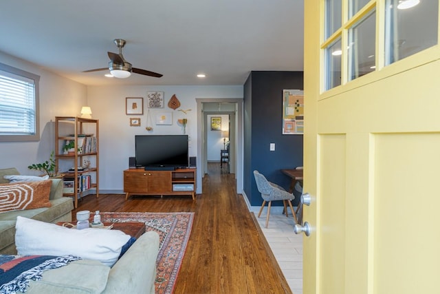 living room with ceiling fan and dark wood-type flooring